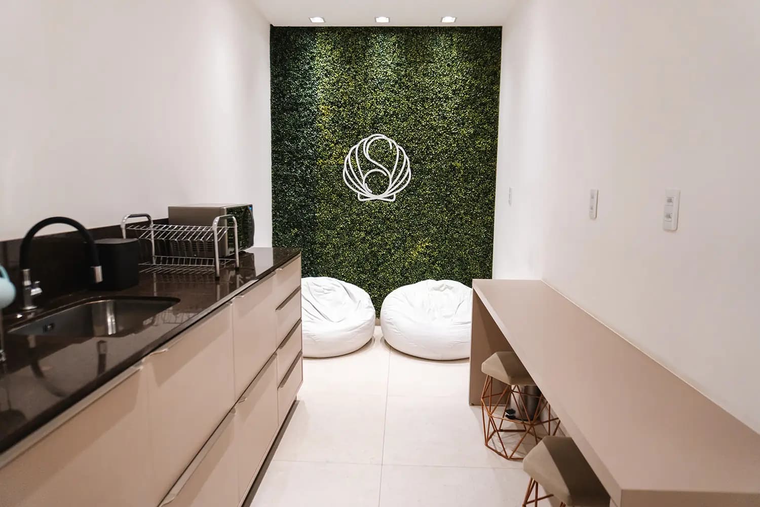 Copa e área de apoio com bancada e parede de jardim vertical